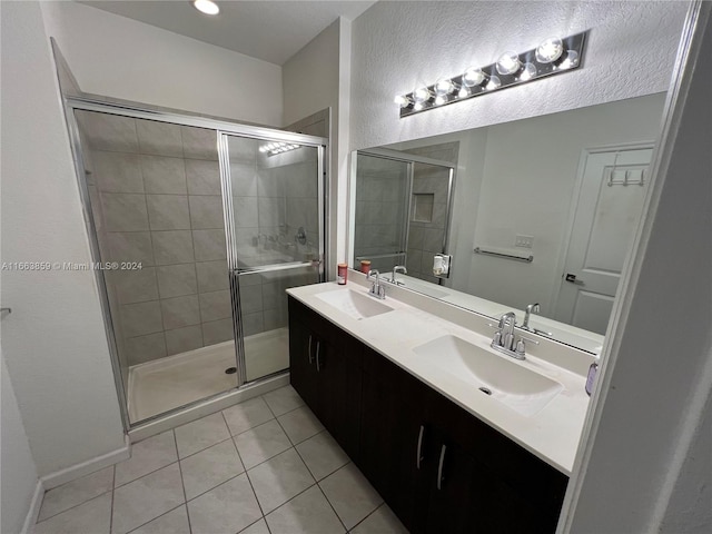 bathroom featuring tile patterned flooring, an enclosed shower, and vanity