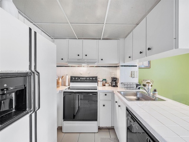 kitchen with tasteful backsplash, white cabinets, white appliances, sink, and light tile patterned flooring