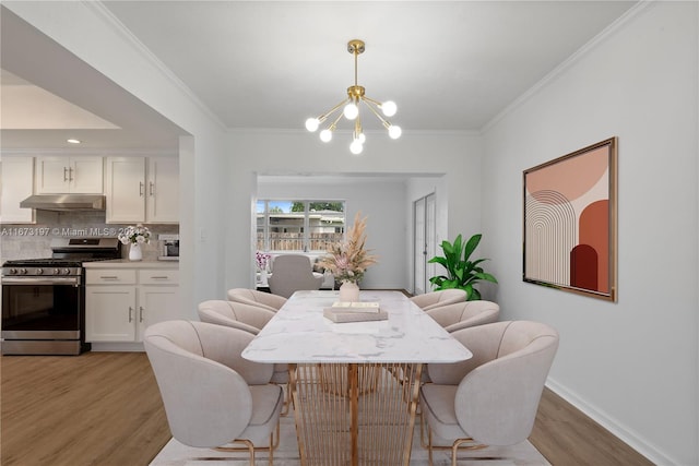 dining space with an inviting chandelier, ornamental molding, and light hardwood / wood-style flooring