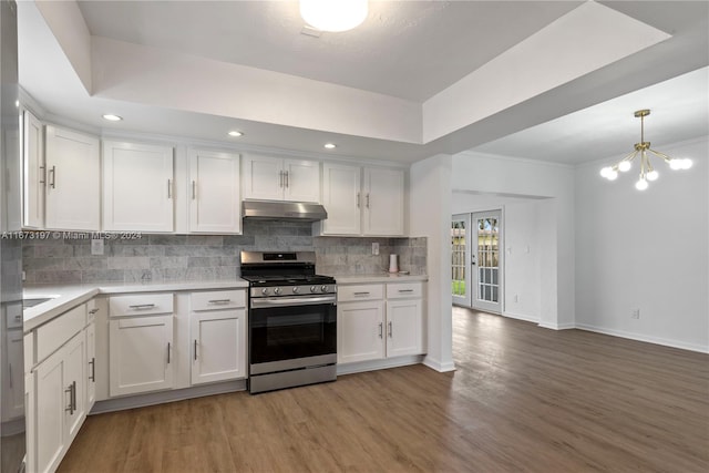 kitchen featuring light wood-type flooring, tasteful backsplash, stainless steel range oven, a chandelier, and white cabinetry