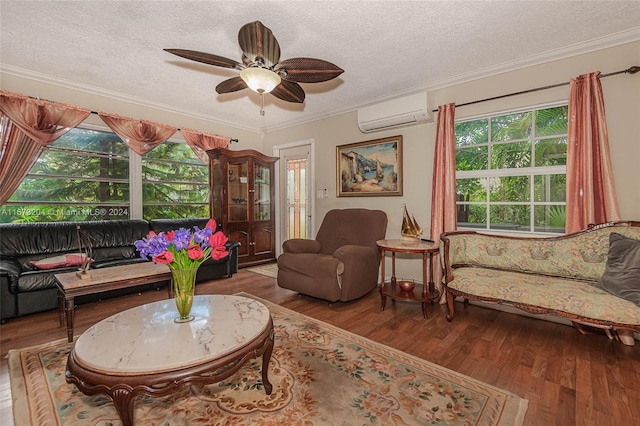 living area with ornamental molding, hardwood / wood-style floors, a wall unit AC, and a textured ceiling