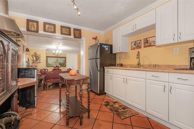 kitchen with crown molding, pendant lighting, white cabinets, and stainless steel refrigerator