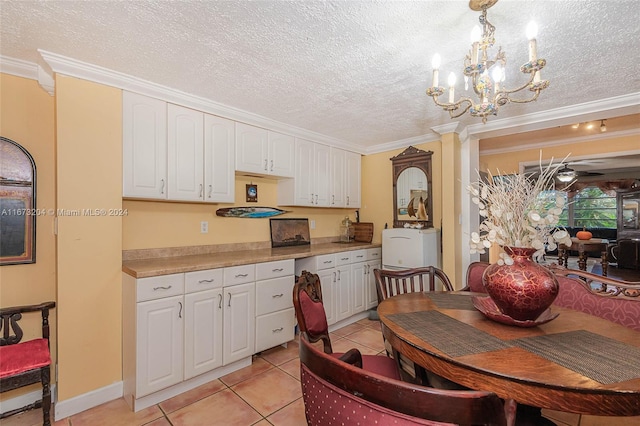 kitchen featuring white cabinetry, decorative light fixtures, crown molding, and light tile patterned flooring