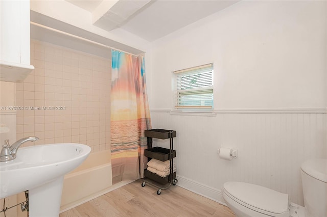 full bathroom featuring hardwood / wood-style flooring, sink, shower / bath combination with curtain, and toilet