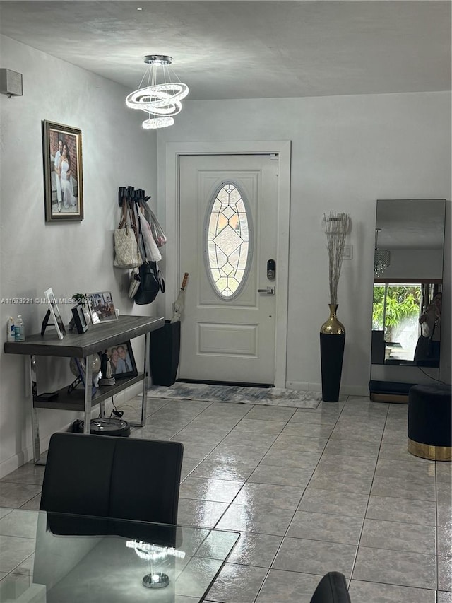 tiled foyer with a chandelier