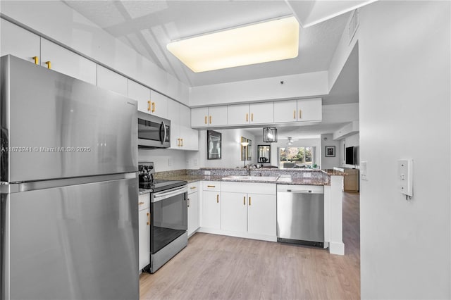 kitchen with white cabinetry, kitchen peninsula, and appliances with stainless steel finishes