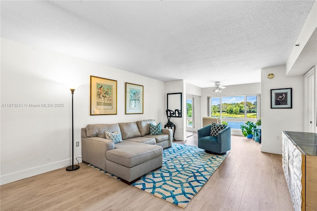 living room featuring a textured ceiling, hardwood / wood-style flooring, and ceiling fan