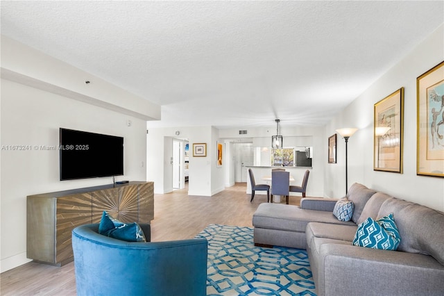 living room with light hardwood / wood-style floors and a textured ceiling