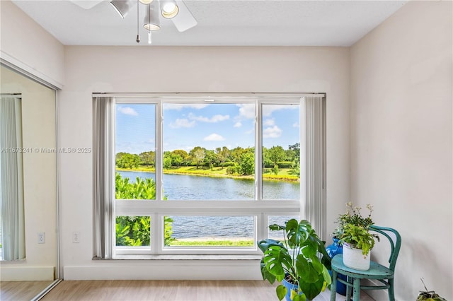 interior space featuring a water view and ceiling fan