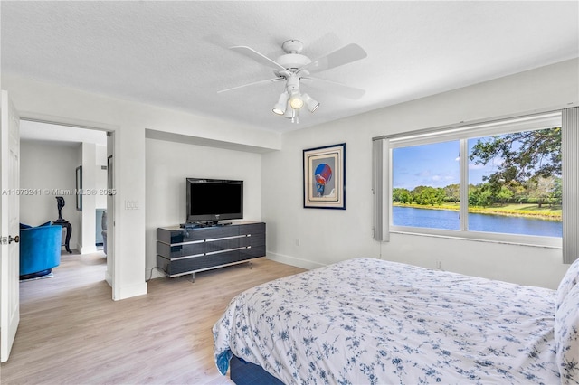 bedroom featuring a textured ceiling, light hardwood / wood-style floors, and ceiling fan