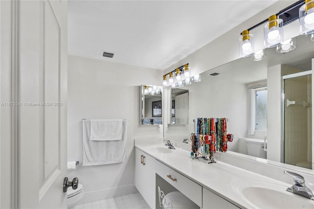 bathroom with tile patterned floors, vanity, toilet, and a shower with shower door