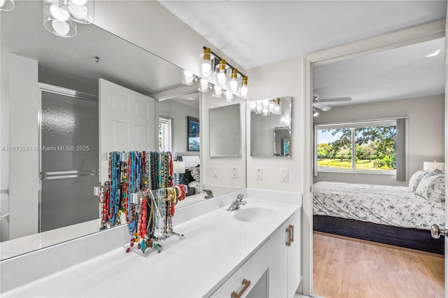 bathroom featuring walk in shower, wood-type flooring, vanity, and ceiling fan