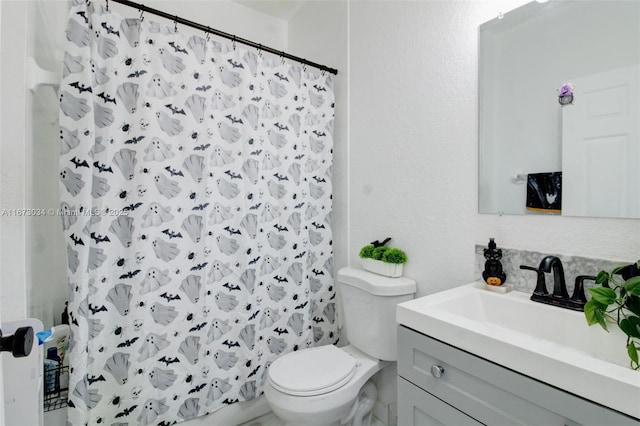 bathroom with vanity, a shower with shower curtain, and toilet