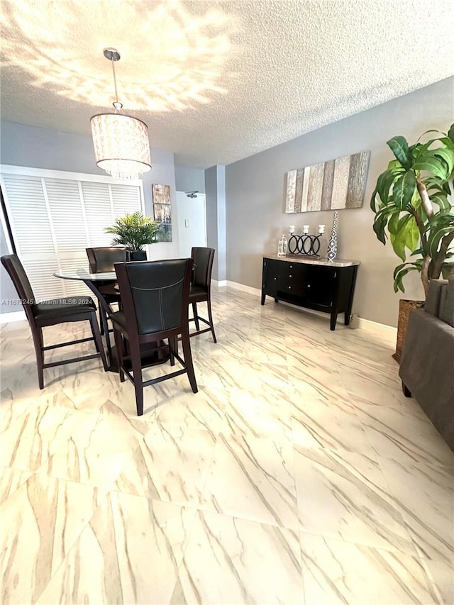 dining area with a textured ceiling and an inviting chandelier