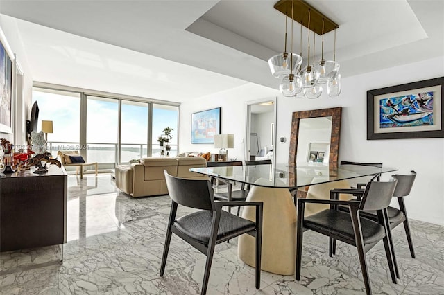 dining area featuring a notable chandelier and a tray ceiling