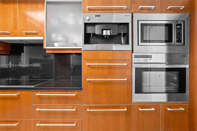 kitchen featuring stainless steel microwave, tasteful backsplash, and black electric cooktop