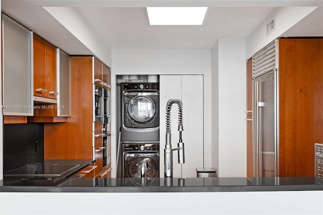 interior space featuring stovetop, stacked washer / drying machine, and extractor fan