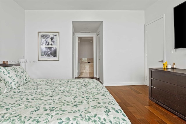 bedroom with dark hardwood / wood-style flooring