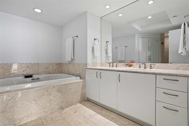 bathroom with tile patterned flooring, independent shower and bath, and vanity