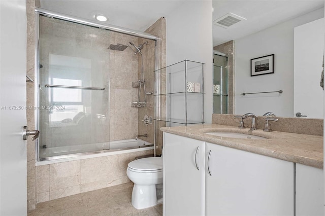 full bathroom with vanity, combined bath / shower with glass door, toilet, and tile patterned floors