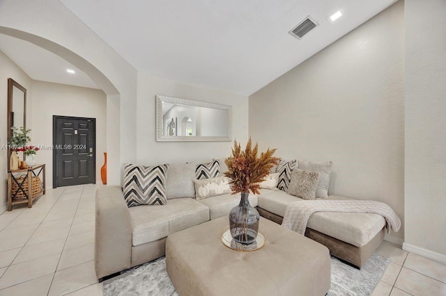 living room with lofted ceiling and light tile patterned floors