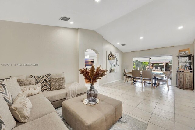 living room with light tile patterned floors and lofted ceiling