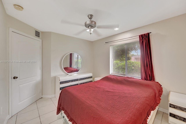 bedroom with multiple windows, light tile patterned floors, and ceiling fan