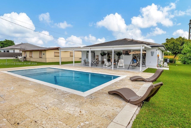 view of pool with a patio area and a lawn