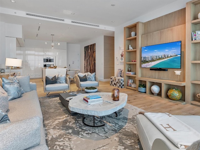 living room featuring built in shelves and hardwood / wood-style flooring