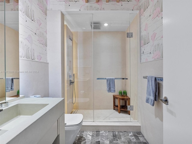 bathroom featuring a shower with door, vanity, and toilet