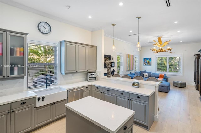 kitchen with pendant lighting, sink, gray cabinetry, dishwasher, and a center island