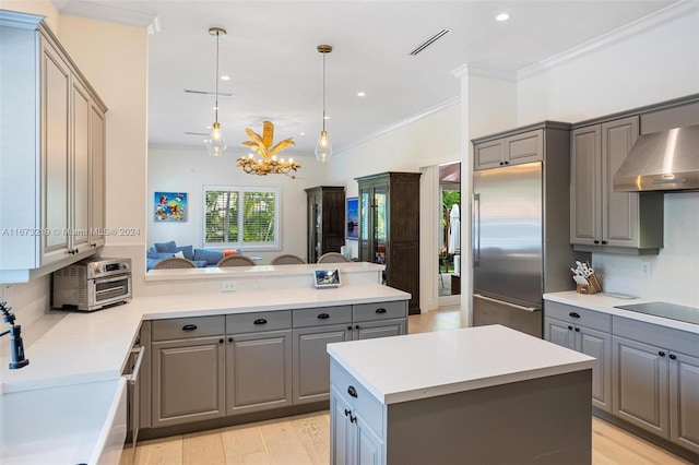 kitchen with backsplash, built in refrigerator, a kitchen island, and gray cabinetry