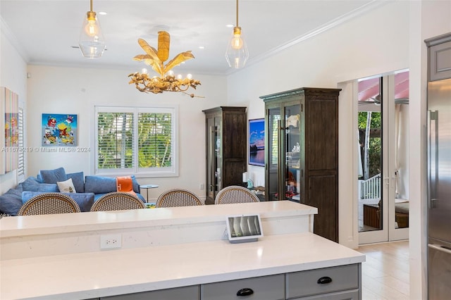 kitchen featuring gray cabinetry, crown molding, pendant lighting, and light wood-type flooring