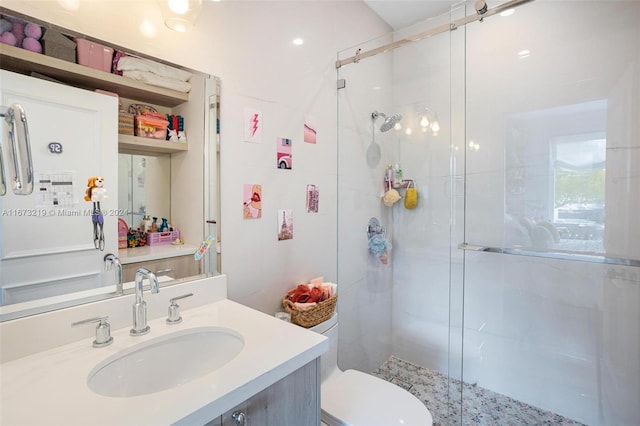 bathroom with vanity, toilet, and a shower with door