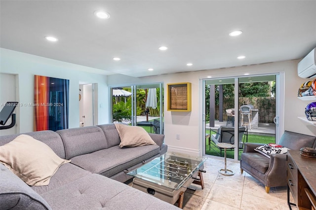 living room featuring light tile patterned floors, an AC wall unit, and a healthy amount of sunlight