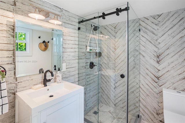 bathroom with vanity, tile walls, and a shower with door