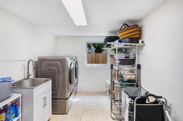 laundry room with washer and dryer, cabinets, and sink