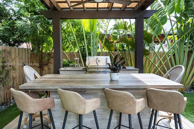 view of patio / terrace featuring an outdoor kitchen, area for grilling, and exterior bar