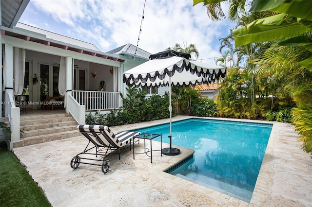 view of pool featuring ceiling fan, french doors, and a patio area