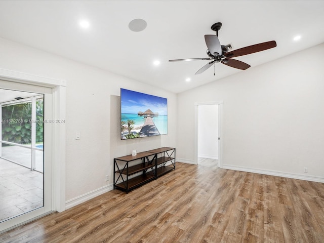 empty room with ceiling fan, light wood-type flooring, and vaulted ceiling