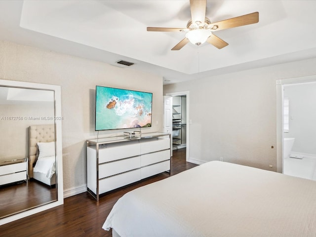 bedroom with connected bathroom, ceiling fan, and dark hardwood / wood-style flooring