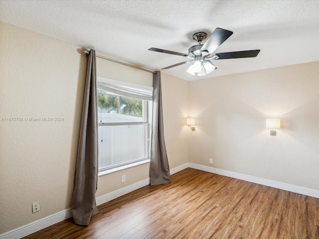 empty room with light wood-type flooring, ceiling fan, and a textured ceiling