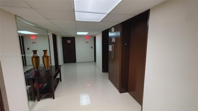 hall featuring a paneled ceiling