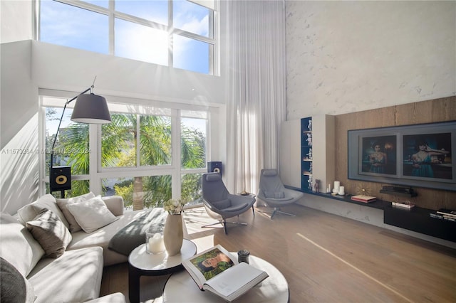 living room with hardwood / wood-style flooring and a high ceiling