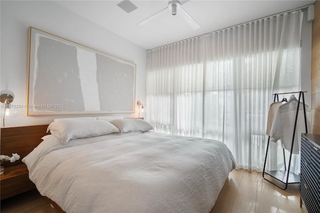 bedroom with light hardwood / wood-style floors and ceiling fan