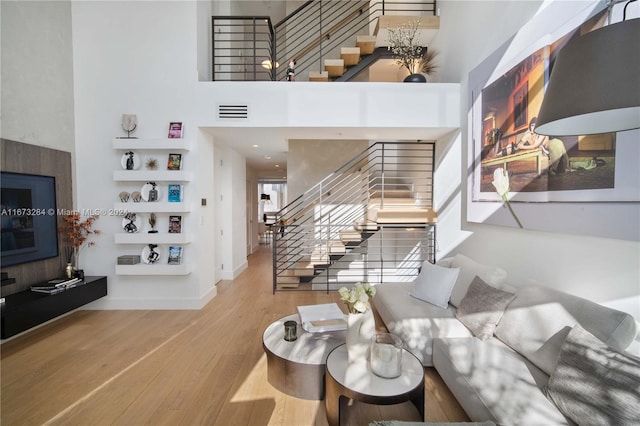 living room with a high ceiling and wood-type flooring