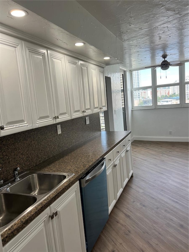 kitchen featuring dishwasher, sink, white cabinets, light hardwood / wood-style flooring, and backsplash