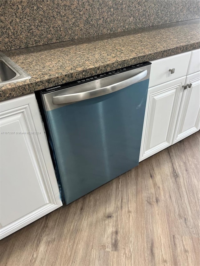 interior details featuring light hardwood / wood-style flooring, white cabinets, dishwasher, and dark stone countertops