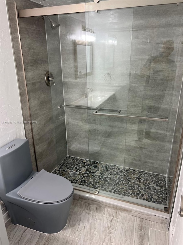 bathroom featuring walk in shower and toilet