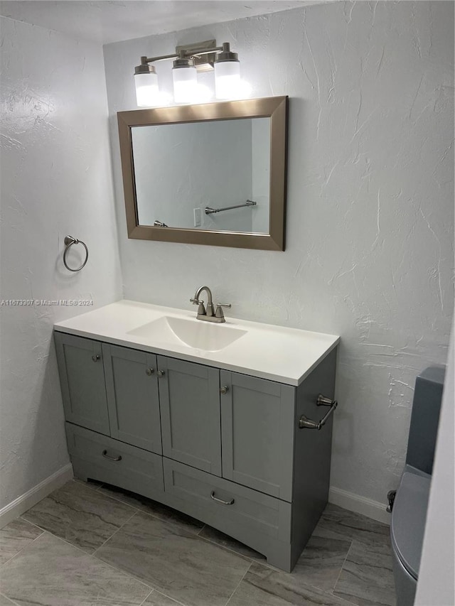 100 Golden Isles Dr Unit 605, Hallandale Beach, FL 33009 - bathroom featuring marble finish floor, vanity, baseboards, and a textured wall